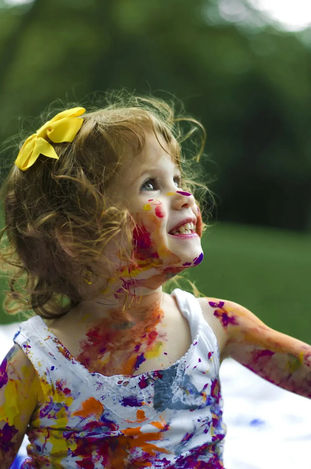 Niña sonriendo con la cara pintada de colores